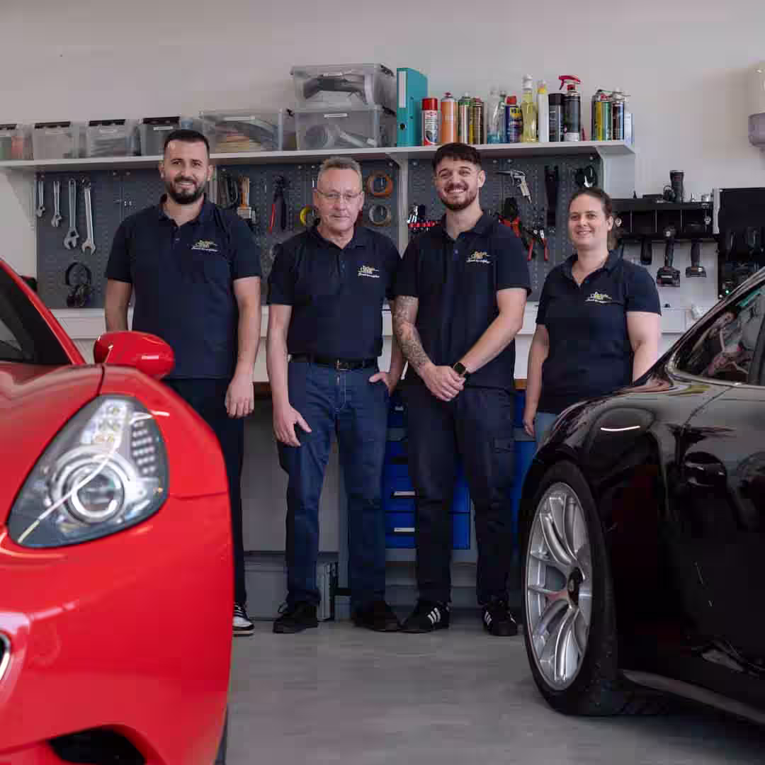 Das Team von Exlusiv Car-HiFi steht neben einem Porsche und einem Ferrari